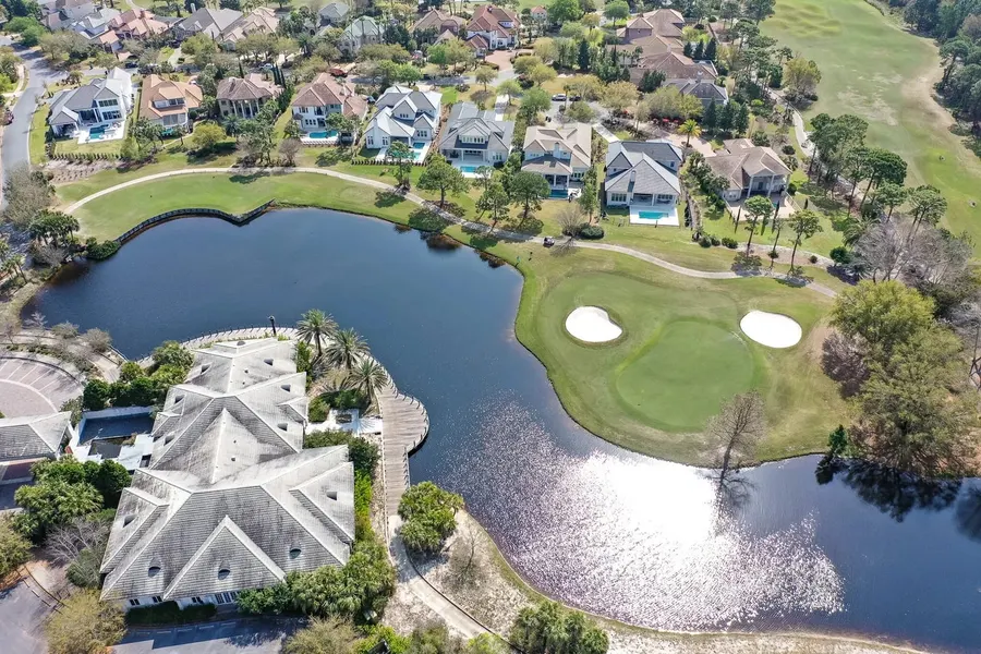 Drone shot of lakefront homes bordering a golf course green