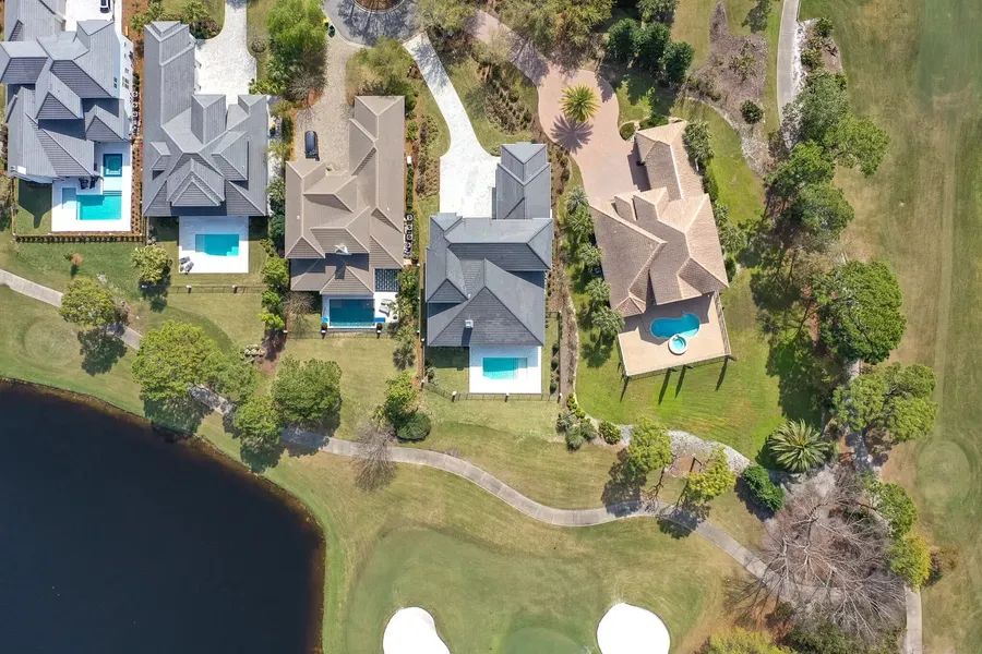 Top-down drone view of pool homes along a Florida golf community
