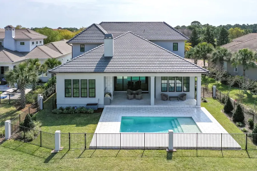 Aerial view of a new home with covered patio and backyard pool