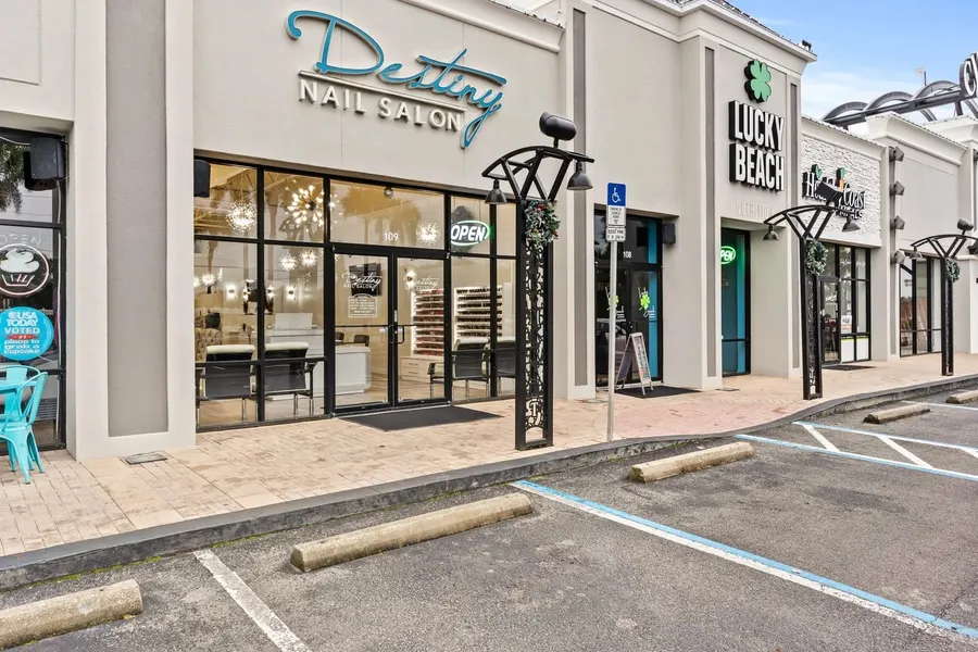 Retail storefronts of a nail salon and shops in a shopping plaza