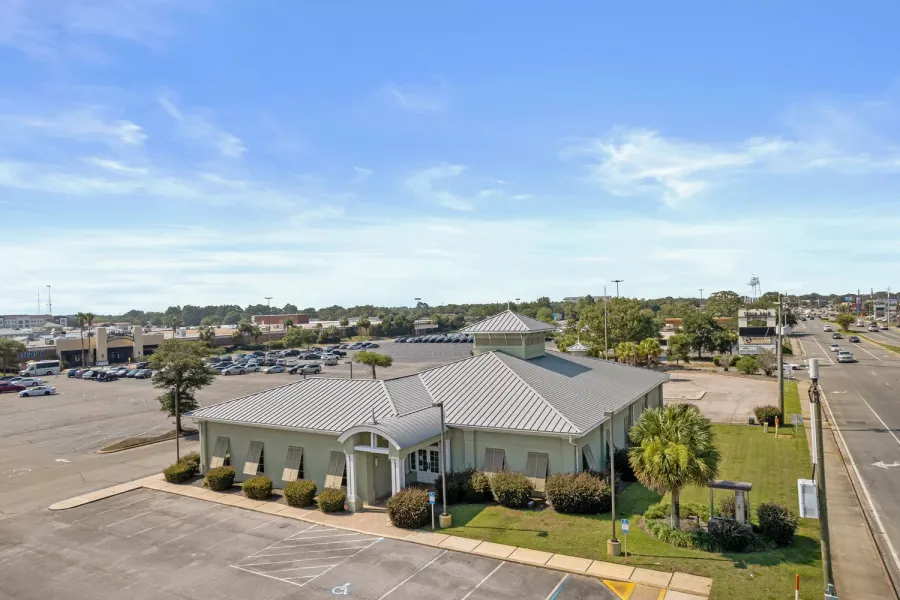 Aerial of a standalone commercial building beside a busy Emerald Coast highway