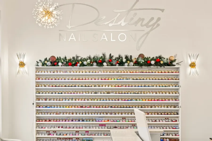 Nail salon polish display wall with holiday garland and starburst sconces