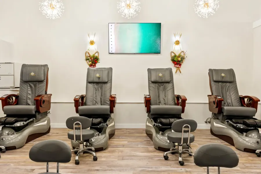 Row of pedicure chairs in a bright nail salon