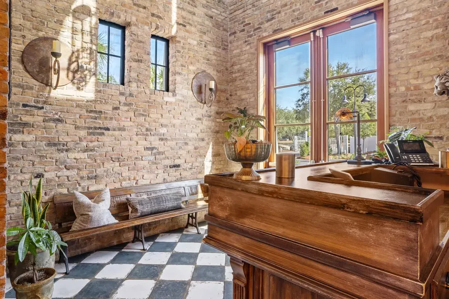 Rustic brick lobby with wood reception desk and checkerboard tile floor