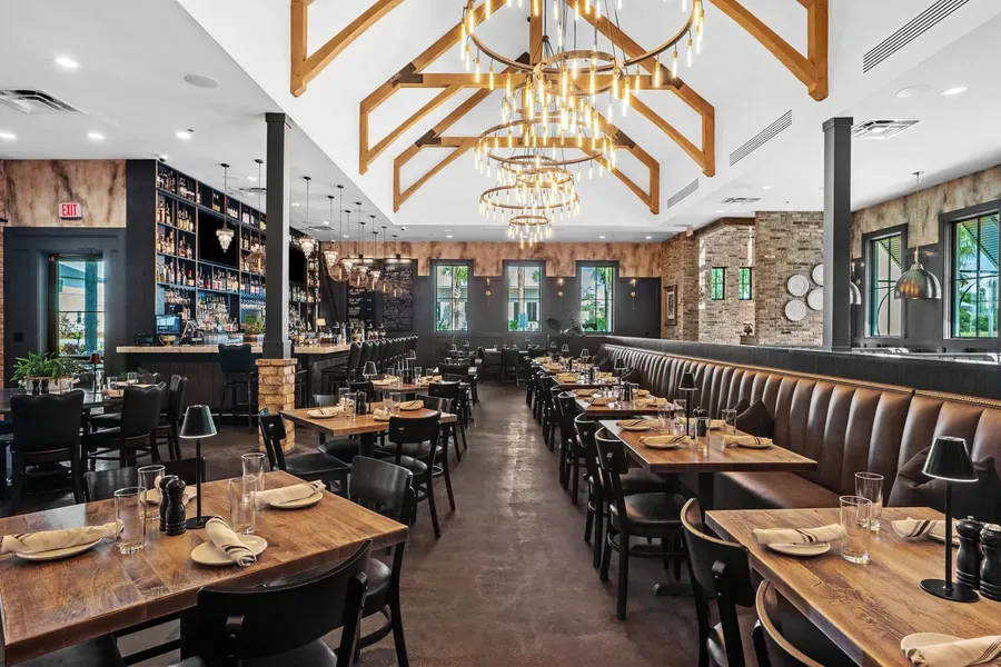Upscale restaurant dining room with chandeliers and exposed wood trusses