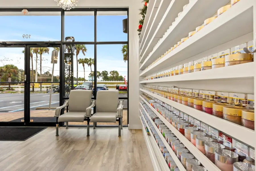 Salon waiting area with product shelves and palm-lined Florida street view