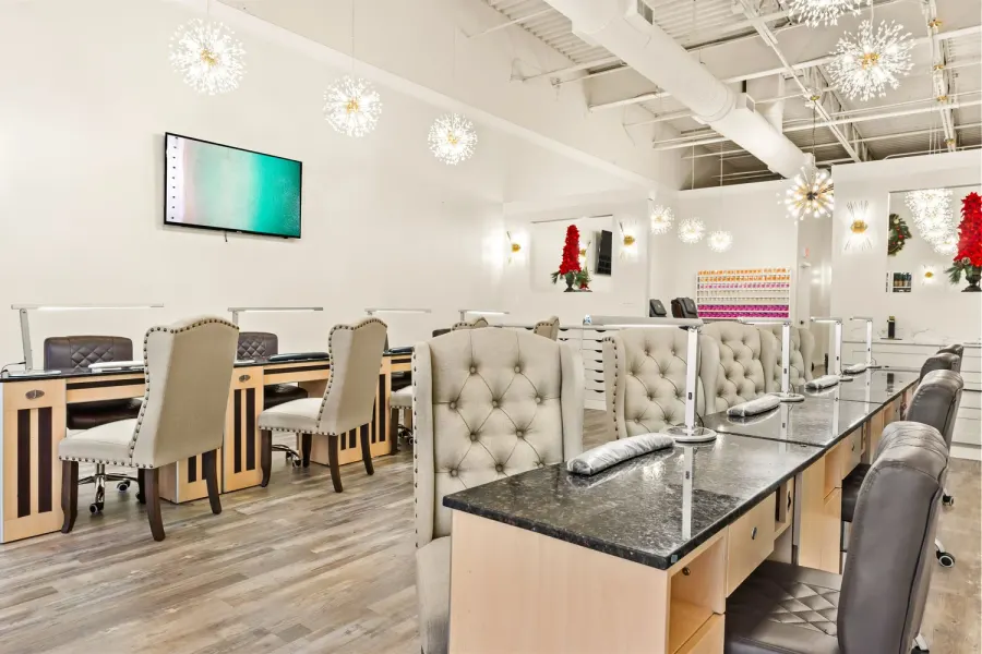 Modern nail salon with tufted chairs, granite tables and sparkling chandeliers