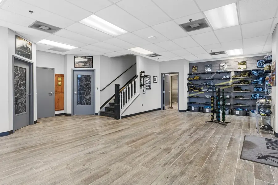 Retail showroom lobby with apparel displays and black staircase