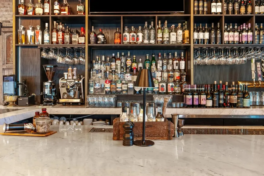 Fully stocked restaurant bar with liquor shelves and marble countertop