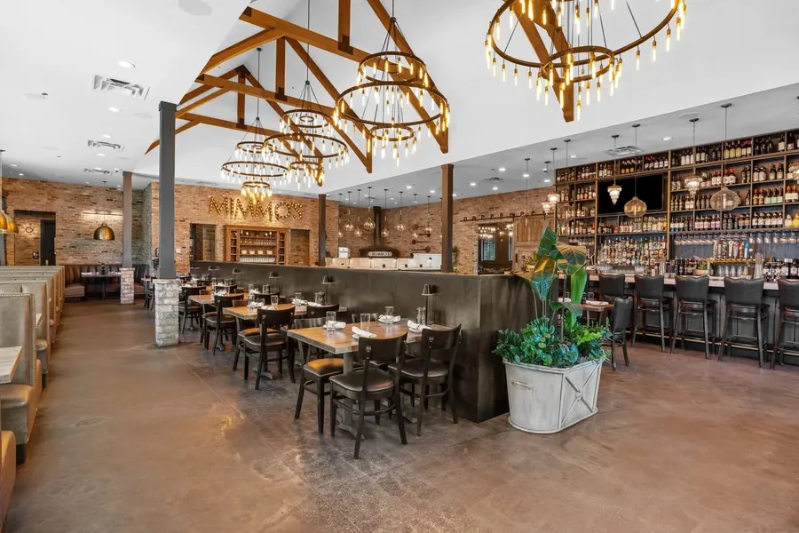 Rustic restaurant dining room with timber trusses, chandeliers and full bar