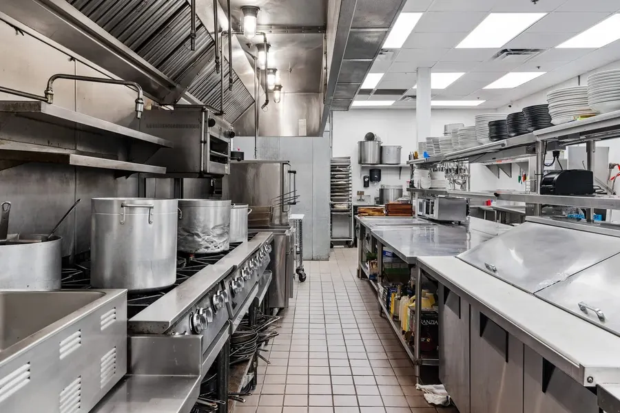 Stainless steel commercial kitchen line with stockpots and prep stations