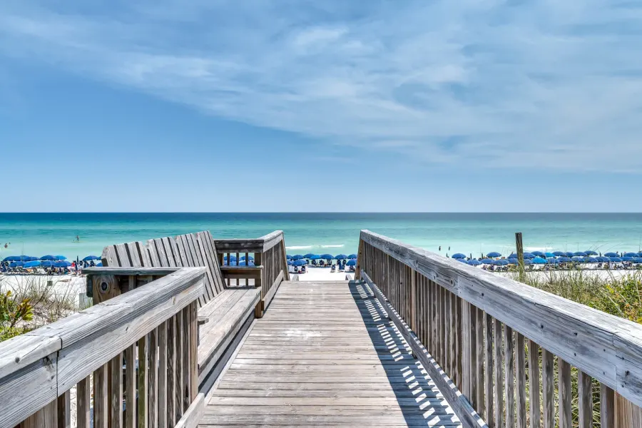 Wooden boardwalk leading to a white sand Destin beach with umbrellas