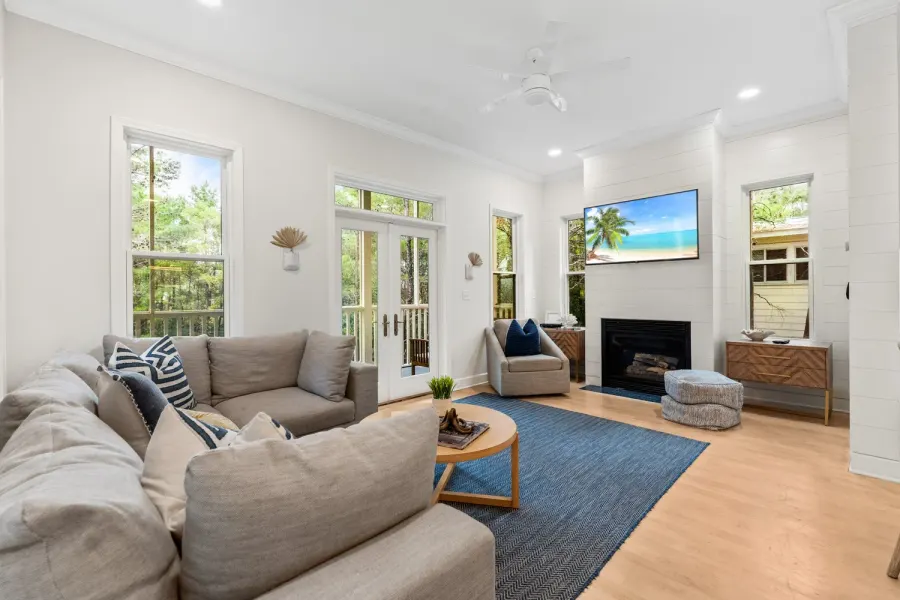 Airy coastal living room with sectional sofa, fireplace, and french doors