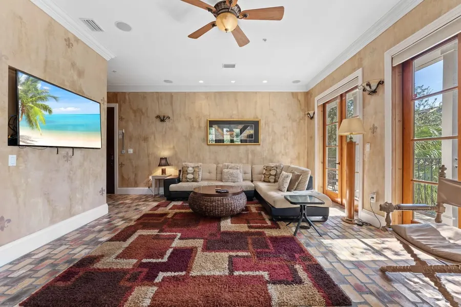Mediterranean living room with faux-finished walls, brick floor, and patterned rug