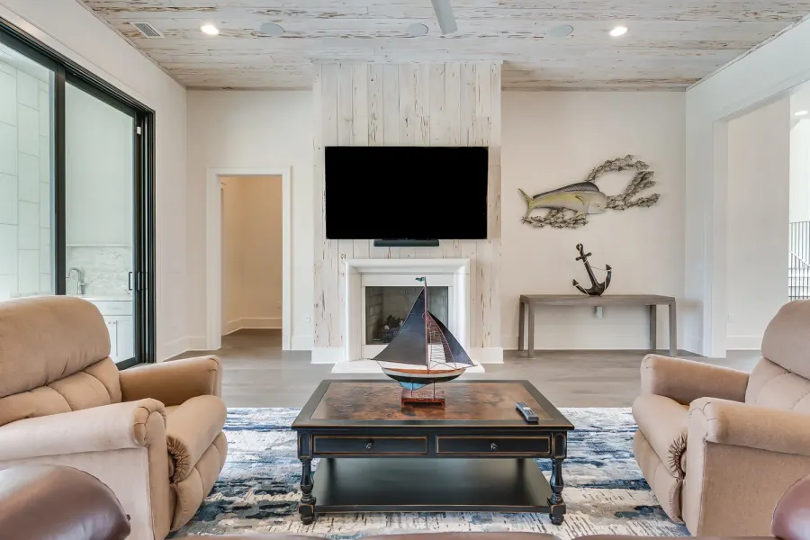 Nautical living room with fireplace, model sailboat, and mounted fish art