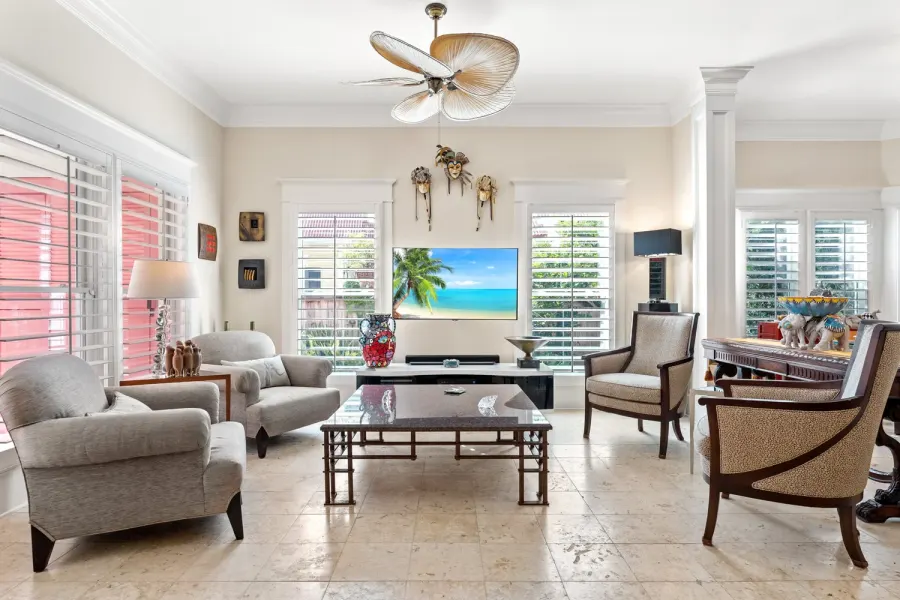 Sunlit living room with plantation shutters and travertine floors