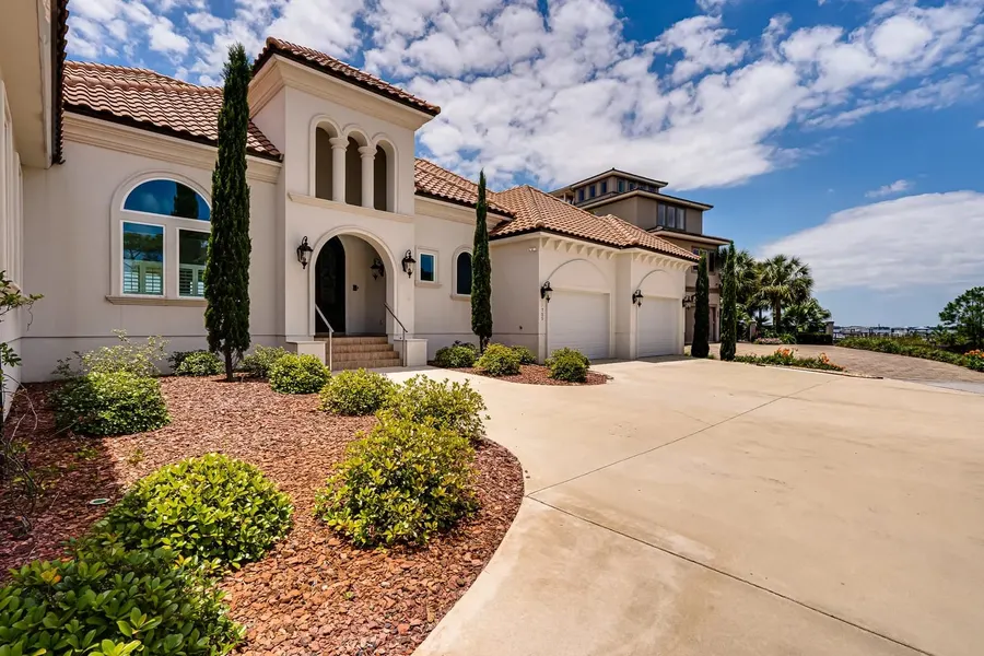 Mediterranean-style Destin home with tile roof and manicured landscaping