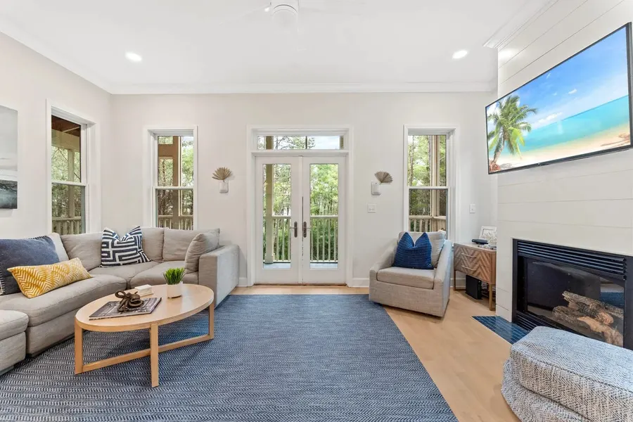 Coastal living room with blue rug, fireplace and French doors