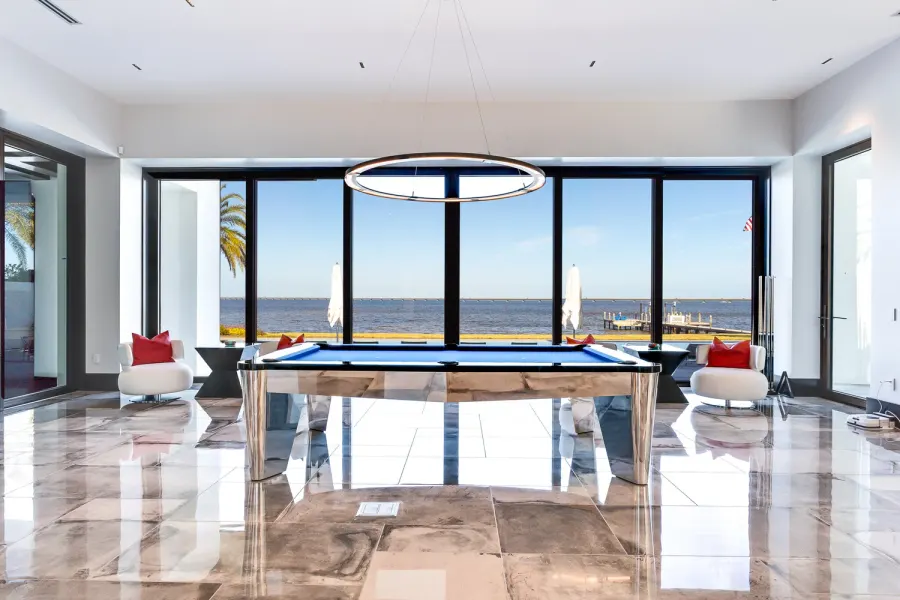 Modern game room with pool table and panoramic waterfront views