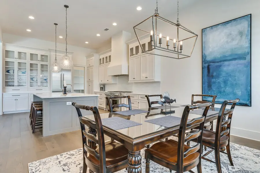 Elegant dining room with lantern chandelier and open kitchen beyond