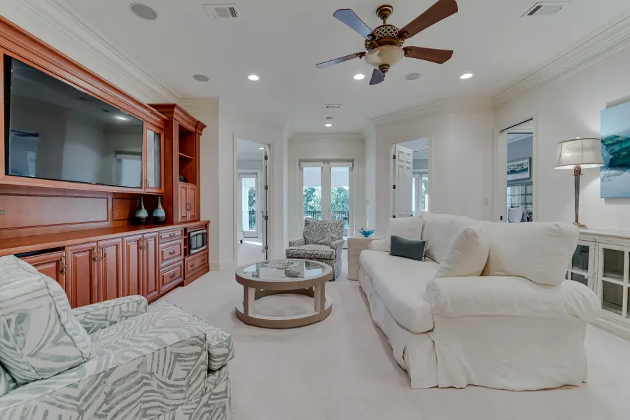 Bright sitting room with entertainment center and slipcovered sofa