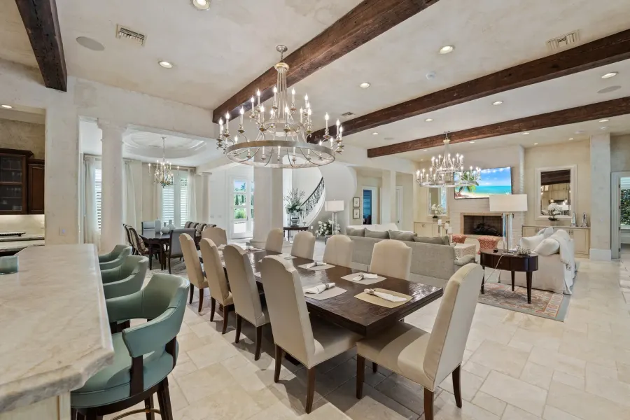 Grand open-concept dining room with wood beams and crystal chandeliers