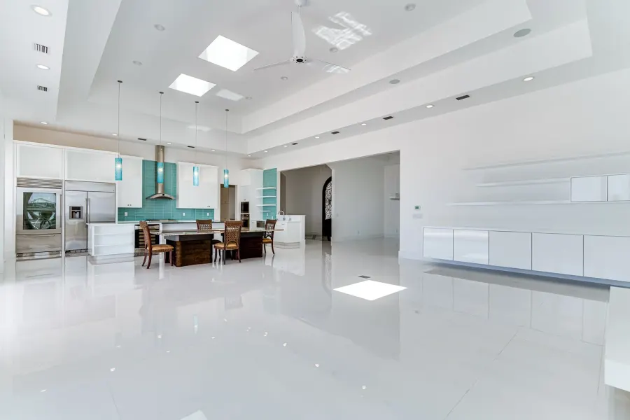 Sleek all-white great room in a Florida home with turquoise tile kitchen