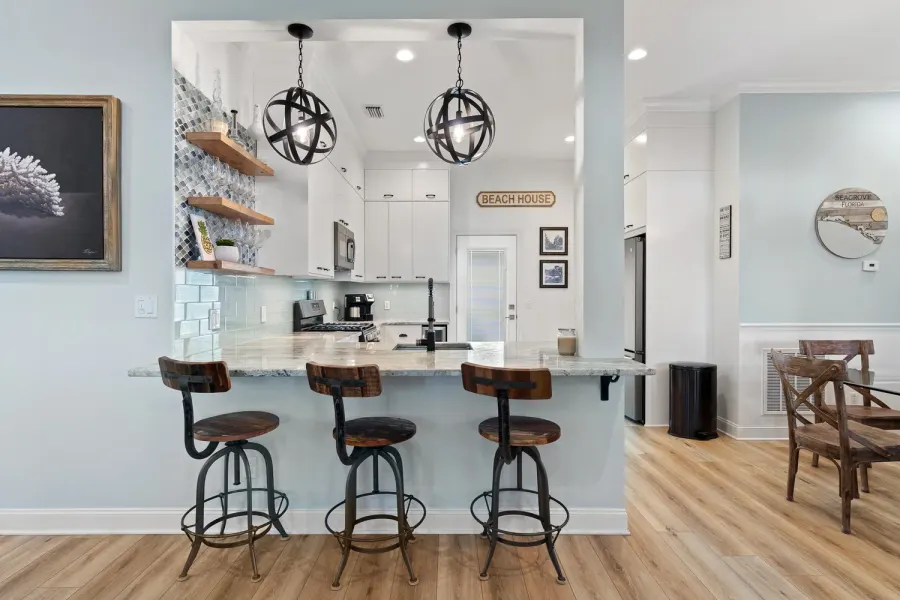 Beach house breakfast bar with rustic stools and orb pendant lights