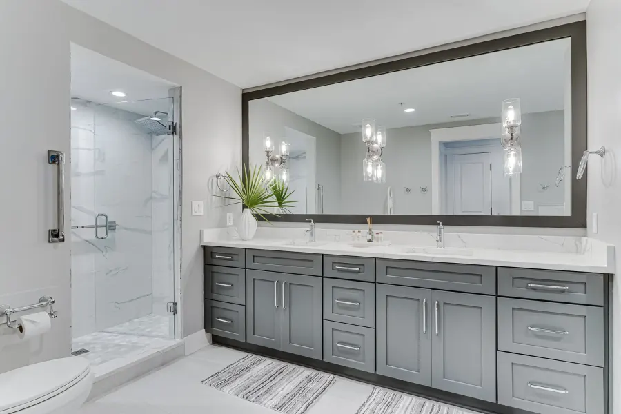 Gray double vanity bathroom with oversized mirror and marble shower