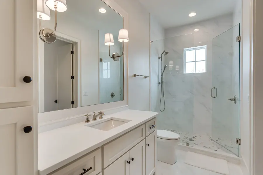 White guest bathroom with marble glass shower and polished nickel fixtures