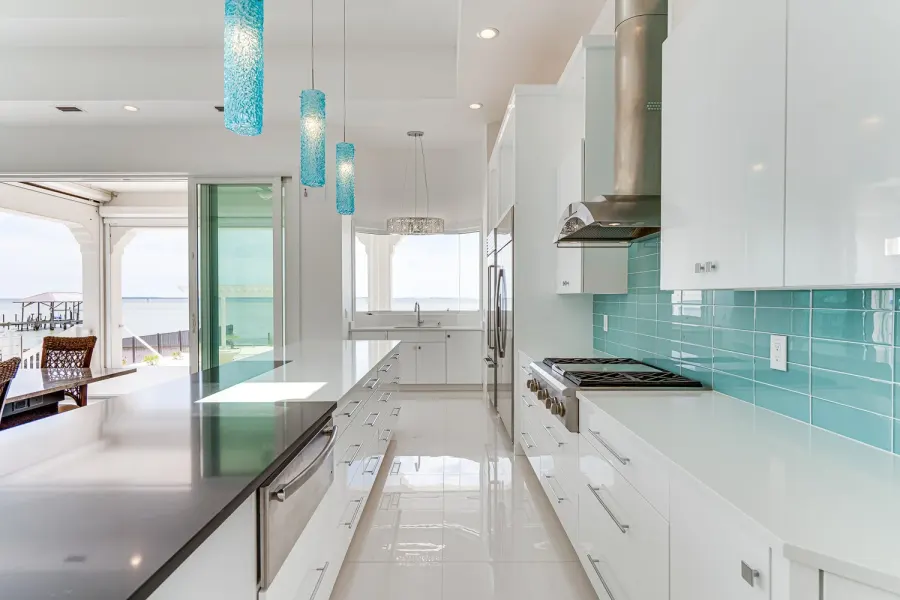 Sleek galley kitchen with turquoise pendants and bay views near Destin