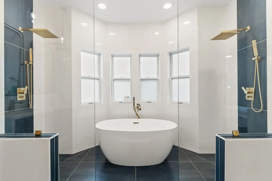 Spa bathroom with oval soaking tub between twin glass rain showers