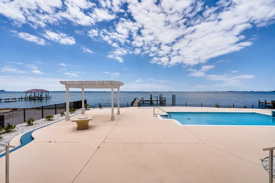 Waterfront pool deck with pergola overlooking Destin's Choctawhatchee Bay