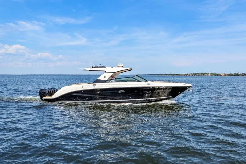 Black-hulled luxury bowrider underway on open blue water