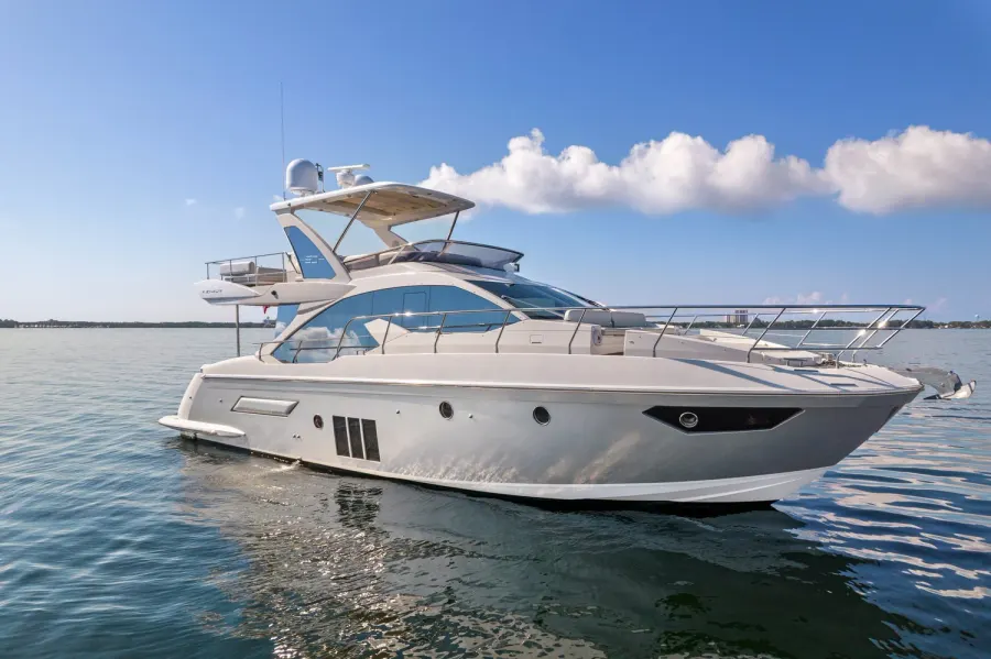 Flybridge motor yacht at anchor under puffy afternoon clouds