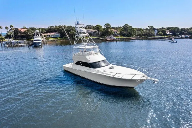 Sportfishing yacht with tuna tower leaving a waterfront harbor