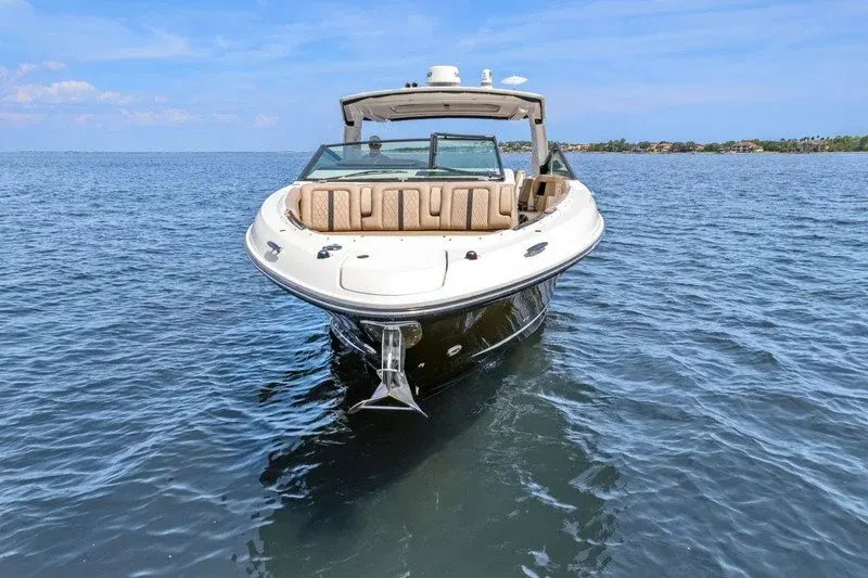 Bow view of a bowrider with tan upholstered seating afloat