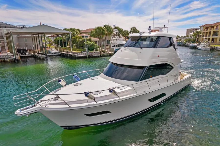Motor yacht navigating a canal past waterfront homes on the Emerald Coast