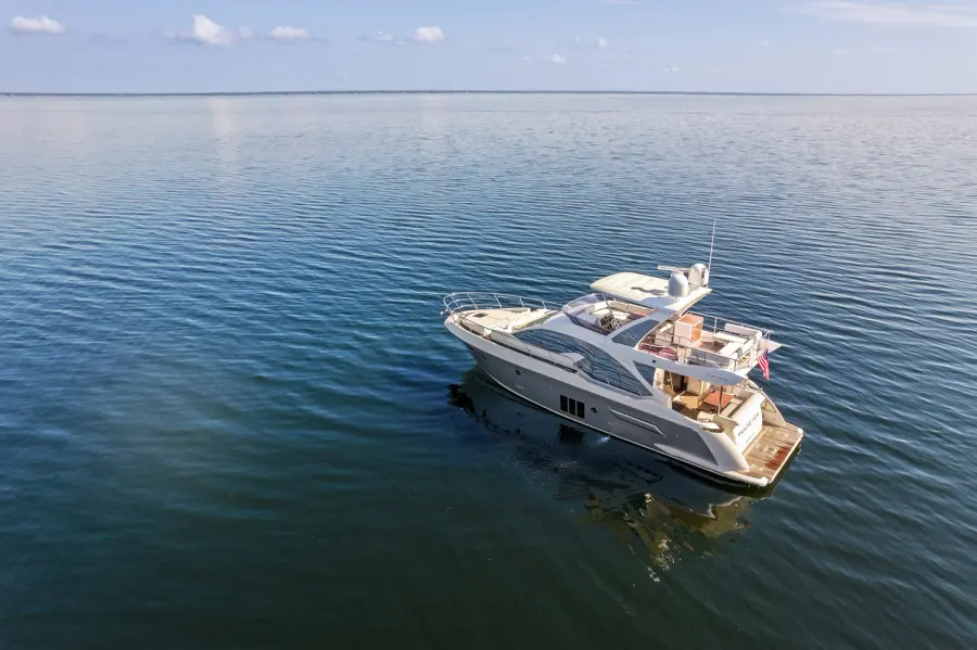 Drone view of a flybridge yacht anchored on glassy open water