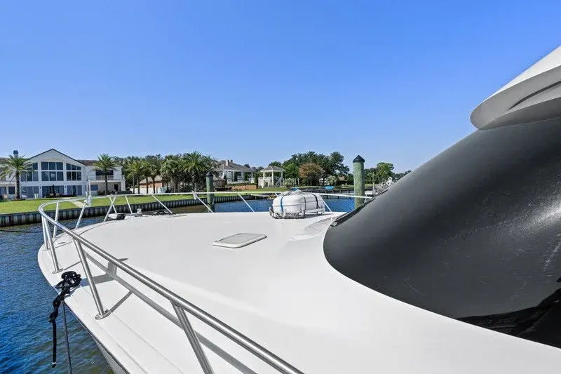 Yacht bow deck at dock with waterfront homes and palms beyond