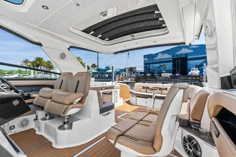 Sea Ray cockpit with tan helm seats, open sunroof, and teak-style flooring