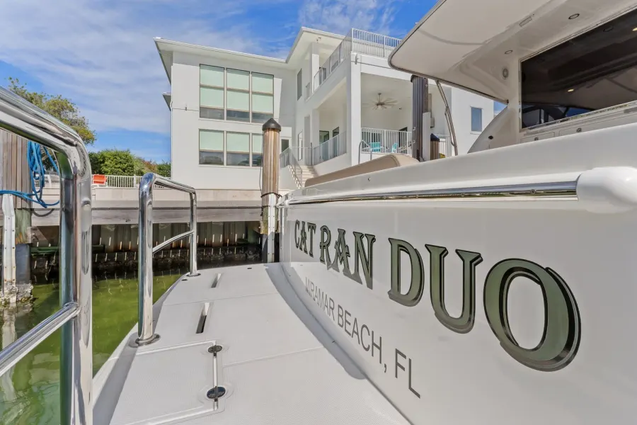 Yacht transom named Cat Ran Duo docked beside a Miramar Beach home