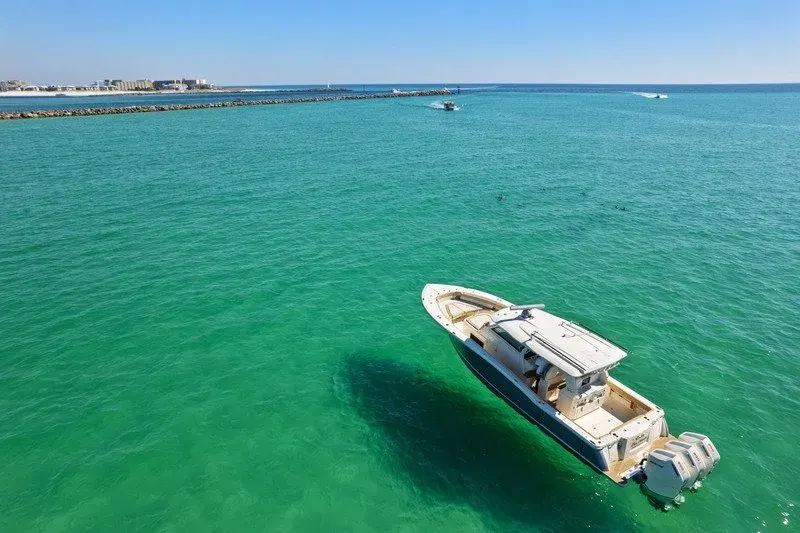 Aerial view of a center console boat on emerald water near Destin jetties