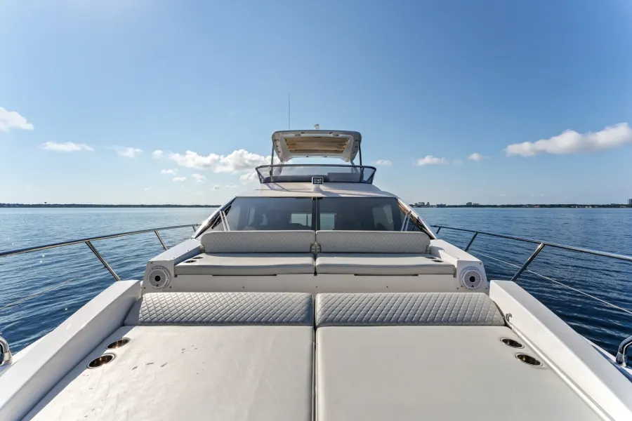 Motor yacht foredeck sun pads and flybridge under a bright blue sky