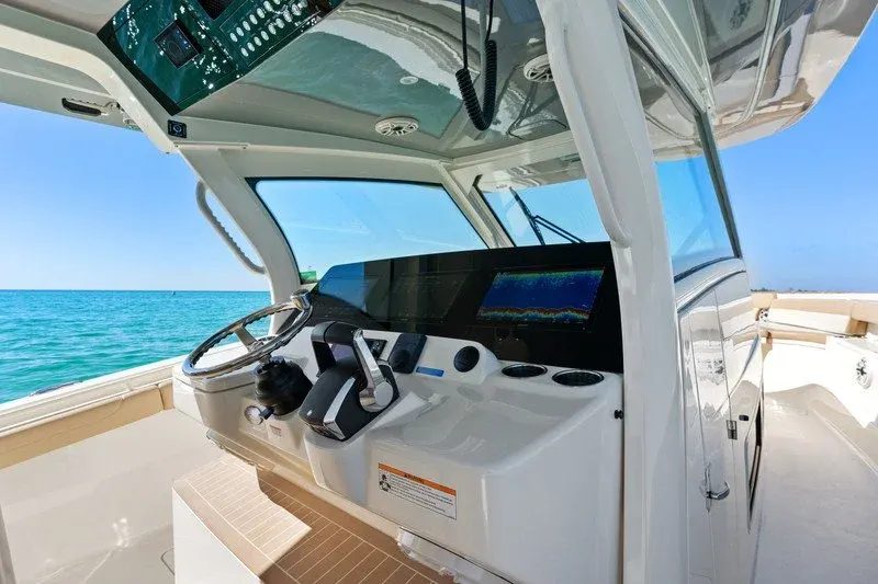 Center console helm with wheel and sonar display over Emerald Coast water