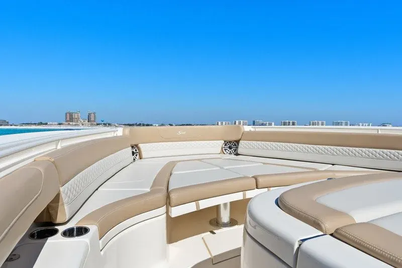 Bow lounge seating on the emerald water with Destin skyline beyond