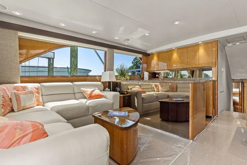 Spacious yacht salon with sectional sofa, coral pillows, and granite bar