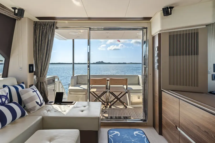 Yacht lounge opening to an aft deck over calm Gulf Coast water