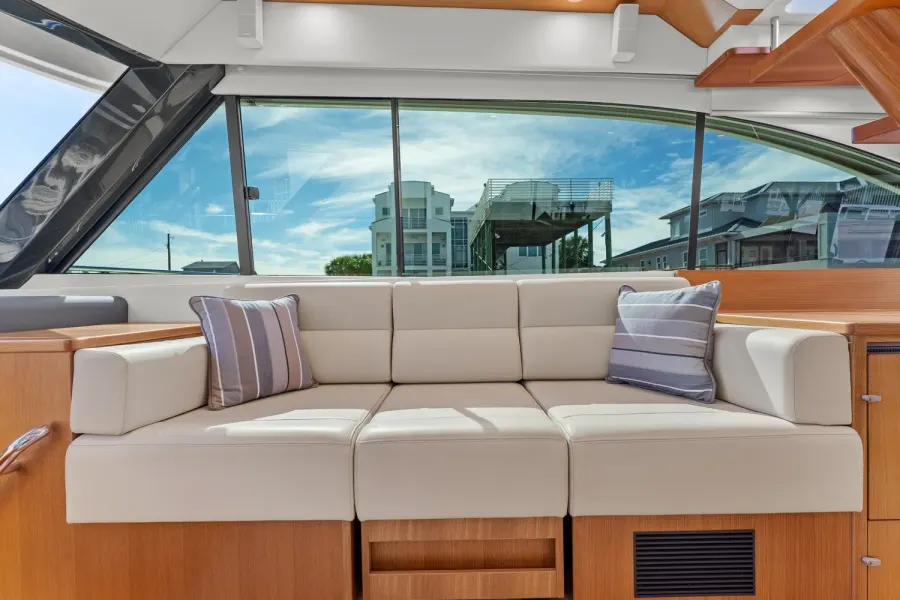 Cream leather yacht sofa with striped pillows and teak cabinetry