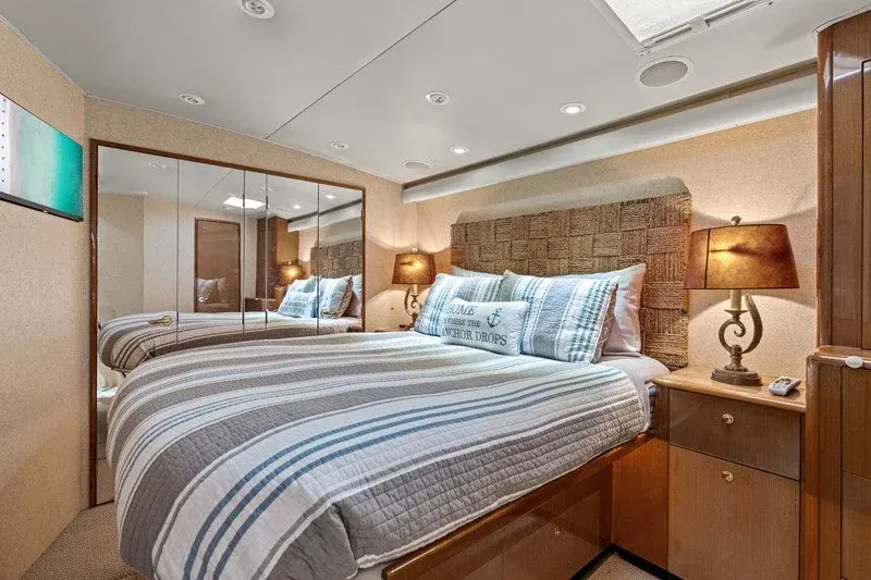Master stateroom with striped bedding, woven headboard, and mirrored closets